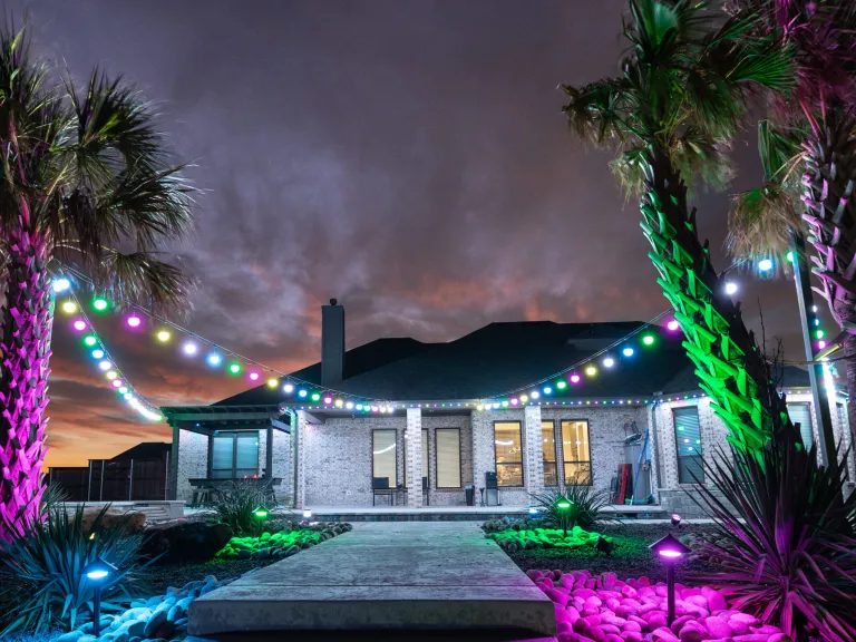 Home with permanent patio and roofline lighting at dusk